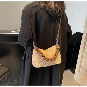 Détail d'un sac bandoulière en peluche beige avec poignée tressée en cuir marron