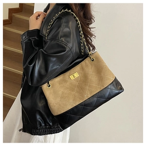 Detail of quilted stitching and gold twist lock on women's two-tone chain tote bag