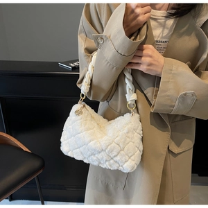 Détail du sac à main matelassé en peluche blanche avec texture douce et boucles dorées