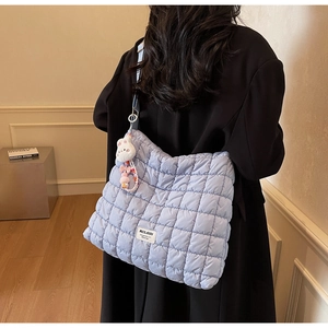 Quilted light blue checkered tote bag detail with cute bunny charm and beaded pendant
