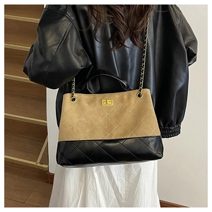 Close-up of diamond quilted pattern and gold twist lock on the two-tone tote bag