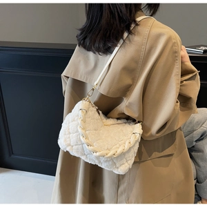 Détail du sac à main matelassé en fausse fourrure avec poignées tressées dorées