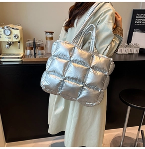 Detail of silver metallic quilted tote bag showing down-padded texture and large capacity