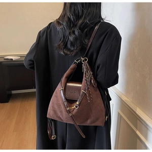 Detail of vintage brown suede tote with leather strap, fringe tassel and gold hardware