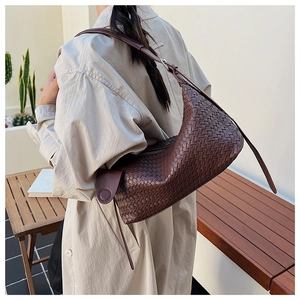 Detail of dark brown woven hobo bag with wide leather straps and vintage texture