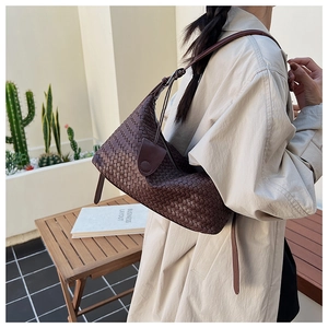 Detail of dark brown woven texture on a versatile crossbody bag with a slim strap