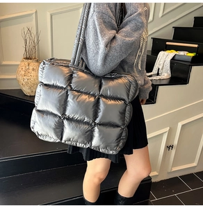 Detailed view of silver quilted down tote bag with metallic finish and long handles