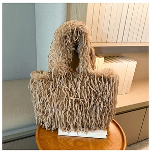 Vue détaillée d'un sac cabas en peluche marron à texture duveteuse sur un tabouret en bois