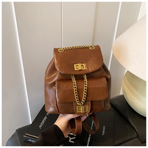 Nahaufnahme eines braunen Retro-Lederrucksacks mit goldener Kette und Metalldrehverschluss