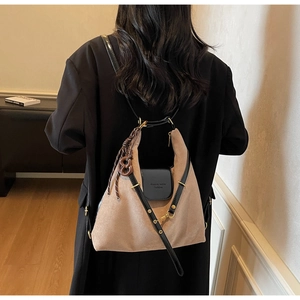 Detailed back view of a khaki suede hobo tote bag with black leather trim and gold hardware