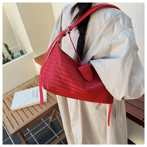 Detail of red woven shoulder bag with adjustable strap and magnetic closure