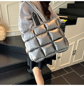 Close-up of metallic silver quilted puffer tote bag with waterproof padded fabric texture