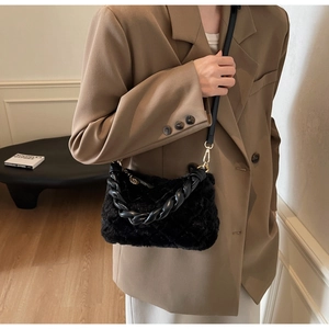 Détail du sac bandoulière en fausse fourrure noire matelassée avec chaîne torsadée