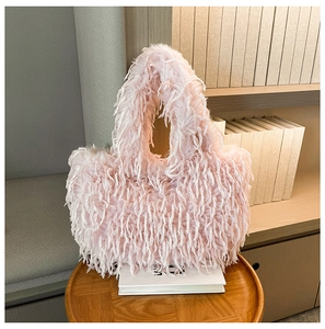 Gros plan du sac fourre-tout en peluche rose avec texture douce sur un tabouret en bois