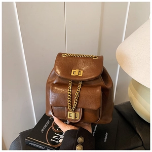 Nahaufnahme des braunen Retro-Rucksacks mit Goldkette und Metallverschluss-Details