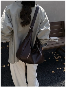 Detail of a chocolate brown leather hobo bag featuring stylish vertical zippers