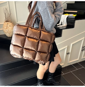 Close-up of metallic quilted puffer tote bag in bronze showing texture and padded design