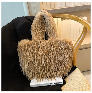 Gros plan du sac cabas en fausse fourrure montrant la texture moelleuse kaki sur une chaise