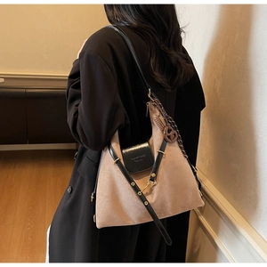 Detail of beige suede tote bag with printed silk scarf wrap and round brown charm