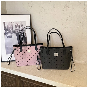 Detail view of pink and grey polka dot tote bags with ribbon prints and metal logo plates