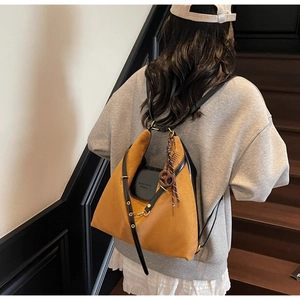 Detail view of a vintage patchwork tote bag featuring brown suede and black leather texture