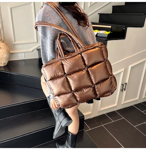 Detail of quilted metallic tote bag featuring square padding and dual carry straps