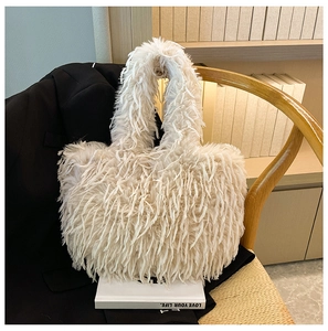 Gros plan du sac cabas en peluche blanc cassé sur un costume noir avec détails en fourrure