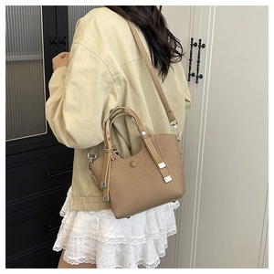 Light brown woven bucket bag shown from behind to demonstrate actual size and proportion