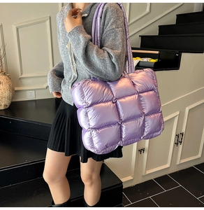 Close-up of a purple quilted puffer tote bag in glossy nylon shown in a lifestyle setting