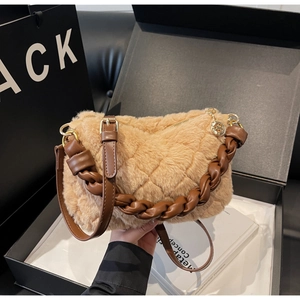 Détail d'un sac à main matelassé en peluche camel avec poignée en cuir tressé