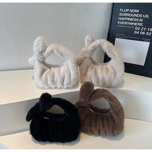 Détail de quatre sacs à main en fausse fourrure blanche, beige, noire et marron avec anses