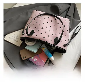 Top view of pink polka dot tote bag showing spacious interior with laptop and cosmetics