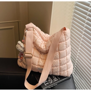 Detail of pink quilted tote bag with diamond pattern and cute rabbit charm accessory