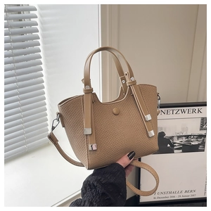 Close-up of khaki bucket bag with woven texture, metal hardware and shoulder strap