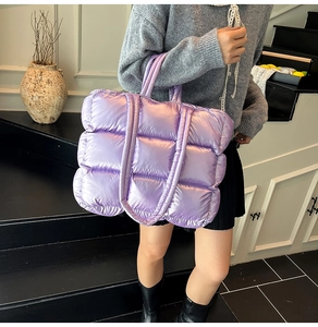 Detail of purple glossy quilted puffy tote bag with soft handles and nylon texture