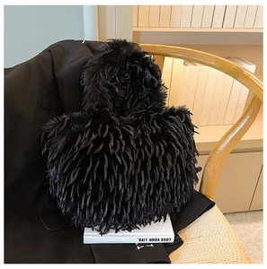 Texture détaillée du sac cabas en fausse fourrure noire posé sur une chaise en bois intérieure