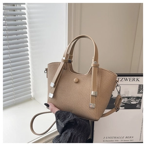Close-up of khaki textured bucket bag with leather handle and silver metal hardware details