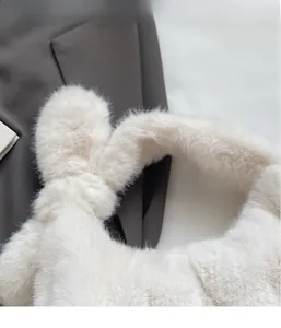 Gros plan sur la texture en fausse fourrure douce d'un sac à main en peluche blanc crème