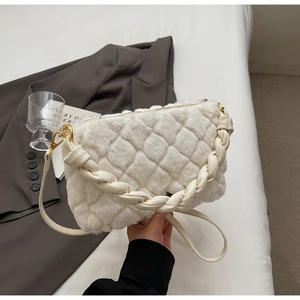 Détail d'un sac en peluche matelassé blanc avec poignée tressée et boucles dorées