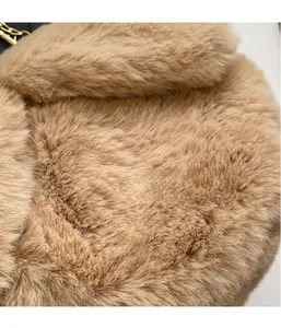Vue macro de la texture en peluche kaki et du détail de la chaîne en métal doré du sac