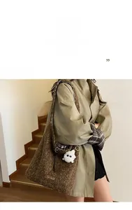 Detail of dark brown faux fur tote bag with plaid strap lining and cute monster charm