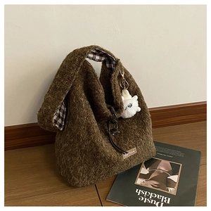 Detail of brown faux fur tote bag with checkered lining and a plush white charm