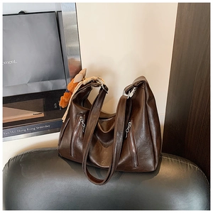 Detailed macro view of dark brown faux leather texture with metal zipper on hobo bag