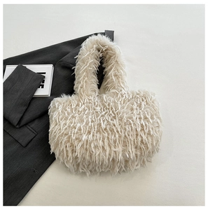 Gros plan sur la texture en fausse fourrure d'un sac cabas d'hiver blanc crème