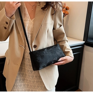 Chic black retro texture shoulder bag styled with a beige blazer and lace skirt