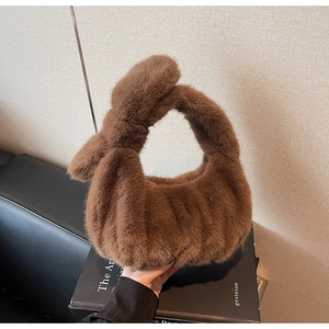 Gros plan détaillé d'un sac à main en peluche marron montrant la texture et l'anse nouée