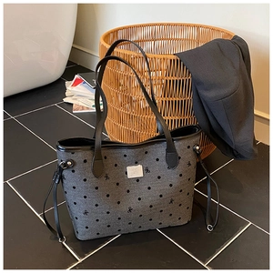 Detailed view of the dark grey canvas tote bag with black polka dots and butterfly embroidery