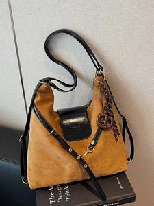 Vintage brown suede tote bag with black leather trim and decorative bow pendant detail