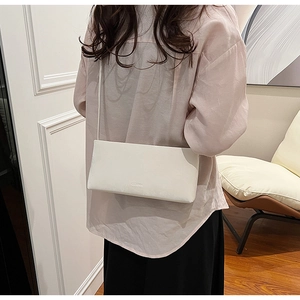 Detailed view of the sleek white faux leather shoulder bag with minimalist branding