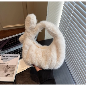 Détail de la poignée nouée et texture en fausse fourrure douce du sac à main en peluche